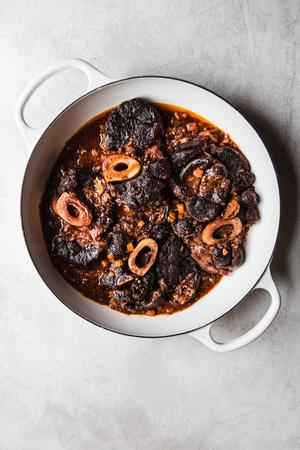 homemade osso buco cross cut beef shanks in a braiser with sauce