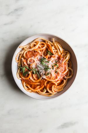 Three Ingredient Tomato Sauce pomodoro sauce with noodles in a bowl with fresh basil and parmesan cheese