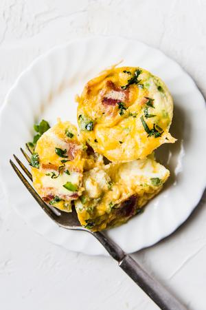 bacon cheddar egg cups on a plate with a fork