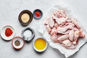 chicken wings, melted butter, salt, pepper, garlic powder, paprika and cayenne in bowls to make baked chicken wings