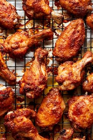 Homemade baked chicken wings seasoned with salt, pepper, garlic powder, paprika and cayenne on a cooling rack