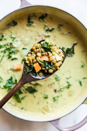 coconut curry lentil soup being ladled out of pot