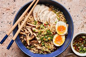 a bowl of easy chicken ramen soup topped with Scallion Chili Sesame Oil, sesame seeds and a halved boiled egg