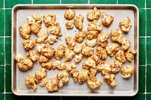 cauliflower tossed with taco seasoning, olive oil and lime juice on a baking sheet to be roasted