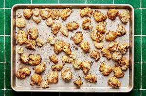 roasted cauliflower seasoned with taco seasoning, olive oil and lime juice on a baking sheet