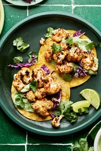 roasted cauliflower tacos on corn tortillas topped with shredded cabbage, cilantro & avocado crema. Served with lime wedges.