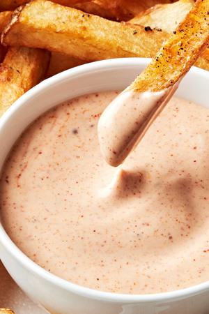 a French fry being dipped into homemade fry sauce