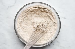 flour, baking soda, salt, cinnamon, cloves and ginger being whisked together in a bowl