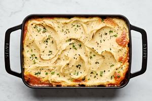 healthy shepherd's pie in a baking dish made with ground beef, onion, carrots, cabbage topped with mashed parsnips