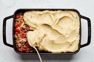 healthy shepherd's pie in a baking dish made with ground beef, onion, carrots, cabbage topped with mashed parsnips