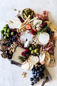 how to build the perfect these board with olives and crackers, nuts and fruit