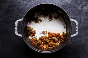 Indian style curry spices with tomatoes and coconut milk in a large pot