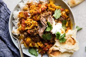 Indian Style Lamb Curry With Cauliflower with cilantro, tomatoes and yogurt.