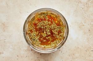 dijon, garlic, salt, pepper lemon juice, oregano, red wine vinegar and vegetable oil in a bowl for Italian salad dressing