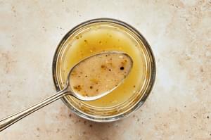 homemade italian salad dressing in a bowl with a spoon on the counter