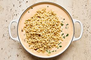 cooked macaroni noodles being stirred into jalapeño popper cheese sauce made with cream cheese, cheddar and pepper jack