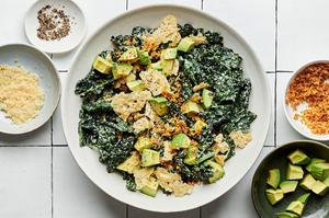 kale caesar salad made with homemade caesar dressing, avocado, toasted panko breadcrumbs and parmesan in a bowl with a fork