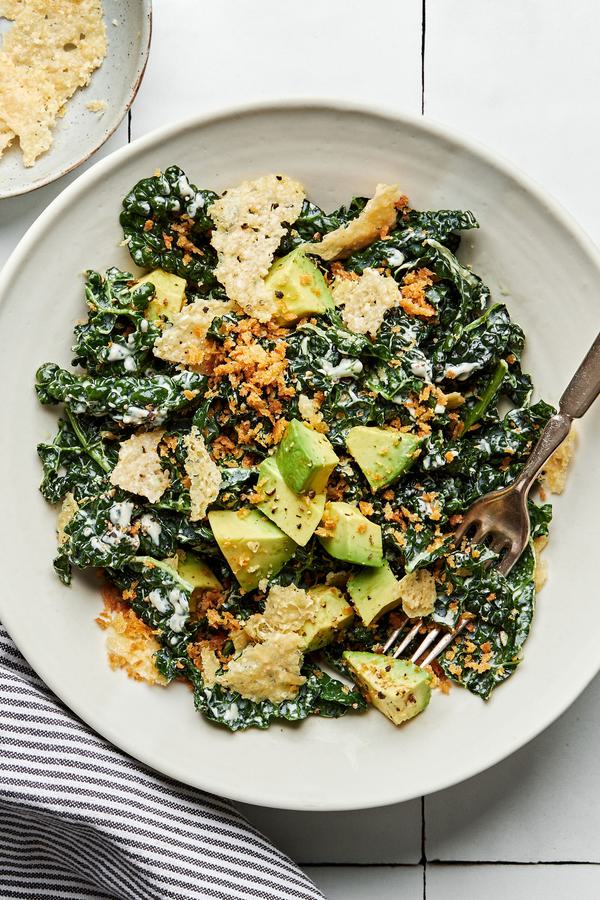 kale caesar salad made with homemade caesar dressing, avocado, toasted panko breadcrumbs and parmesan in a bowl with a fork