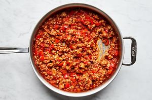 marinara sauce added to a skillet with cooked ground chicken, bell pepper, and garlic