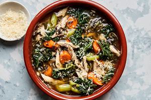 a bowl of Leftover Turkey Soup with Wild Rice made with carrots, celery, onion, garlic, spices and kale topped with Parmesan