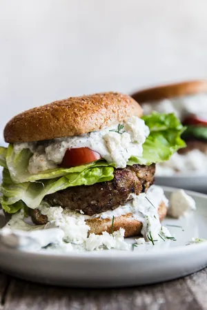 Mediterranean Turkey Burger on a plate with feta, lettuce, tomato and tzatziki sauce
