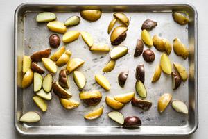potato wedges on a sheet pan with olive oil and salt