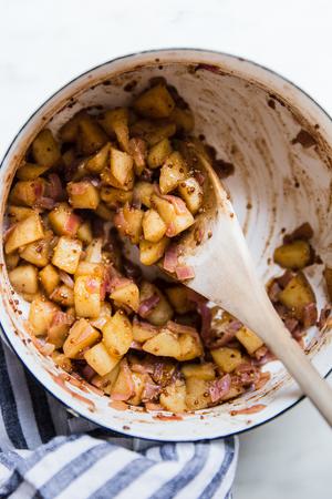 Apple Chutney in a pot with a wooden spoon
