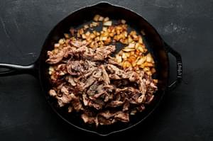 cooked beef and onions in a cast iron skillet to be used for philly cheesesteaks