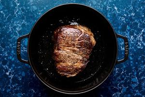 chuck roast seasoned with salt and pepper being browned in olive oil in a pot