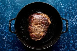 chuck roast seasoned with salt and pepper being browned in olive oil in a pot