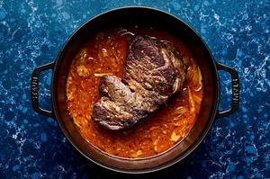 red curry beef made with coconut milk, red curry paste, lime juice, onion, garlic, lemongrass, and ginger in a pot