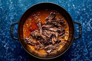 red curry beef being shredded in a soup pot