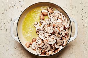 mushrooms being cooked in olive oil and butter in a skillet