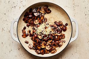 mushrooms and garlic being cooked in olive oil and butter in a skillet to make mushroom sauce