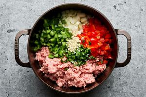 turkey, onion, bell peppers, jalapeño, and garlic being cooked in a soup pot