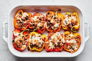 a baking dish filled with ground turkey stuffed peppers topped with melted cheese