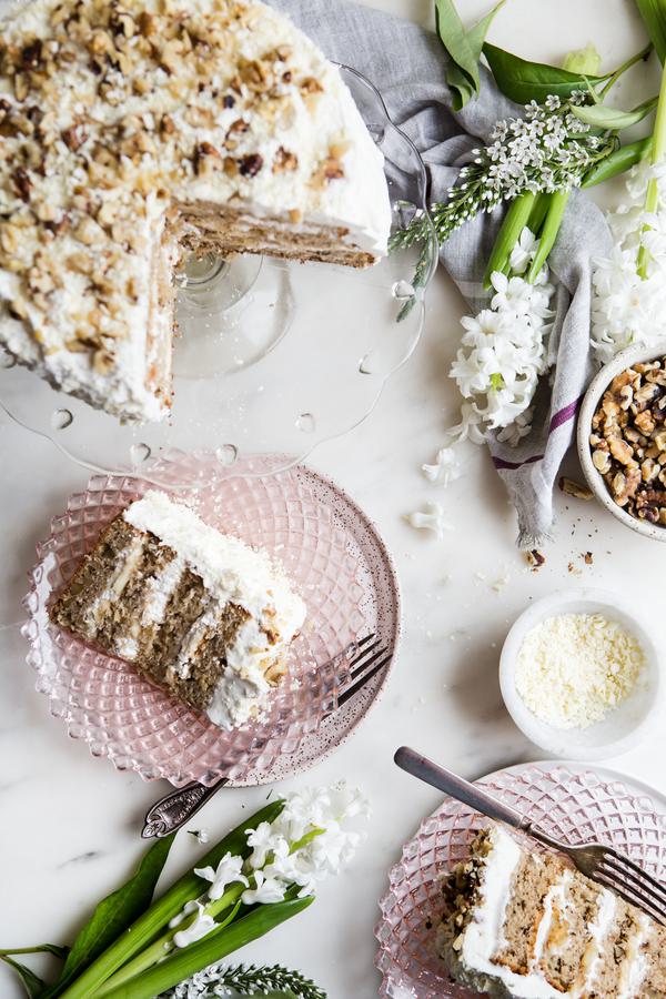 banana walnut cake on a cake stand with two slices on plates