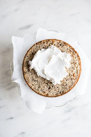 whipped cream frosting on top of a layer of banana cake