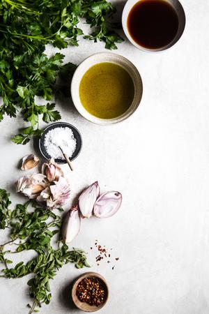 ingredients laid out for chimichurri sauce shallots, salt, olive oil, oregano, parsley