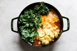 Italian sausage, crushed tomatoes, chicken stock tortellini, cream and kale added to a soup pot for tortellini soup