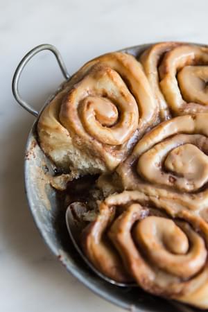 a pan of homemade cinnamon rolls with maple frosting