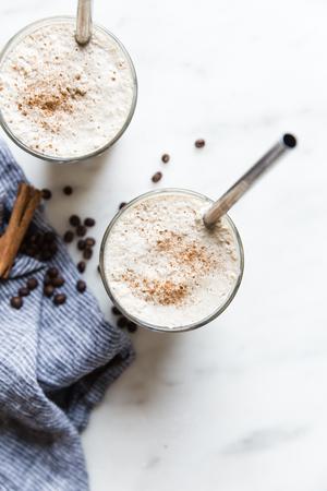 2 glasses filled with Iced bulletproof coffee each with a straw