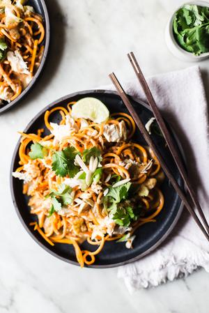 Pad Thai made with sweet potato noodles with cilantro and lime on a plate