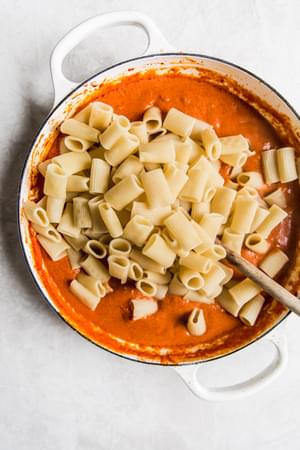 pasta in a pan with tomato cream sauce