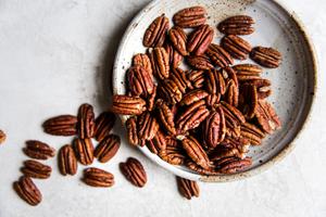 a small plate with raw pecans on it.