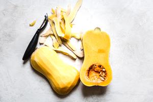 peeling a butternut squash with a vegetable peeler