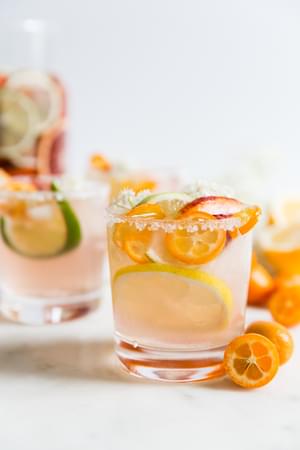Rosé wine sangria in two glasses with citrus fruit