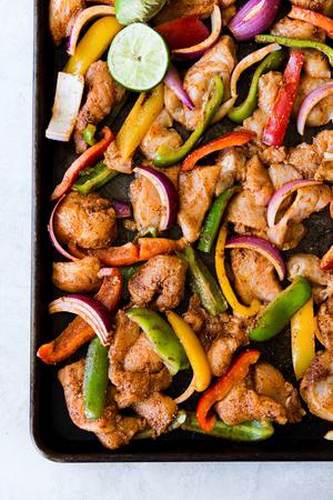 Sliced chicken, red onions and bell peppers marinated in lime juice, taco seasoning and olive oil for chicken fajitas