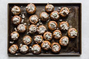 cheese stuffed mushrooms on a baking sheet