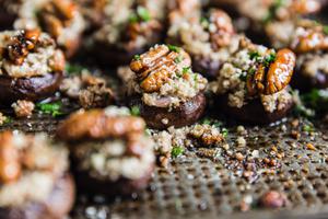 side view of Goat Cheese And Pecan stuffed mushrooms on a baking sheet